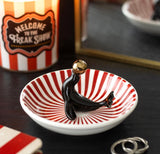 Circus style quirky trinket dish featuring a black circus seal balancing a golden ball gothic alternative twisted circus range